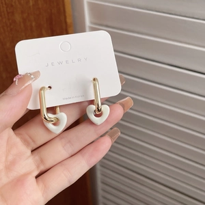 Elegant retro gold rectangle earrings with a white heart pendant on a jewelry display card
