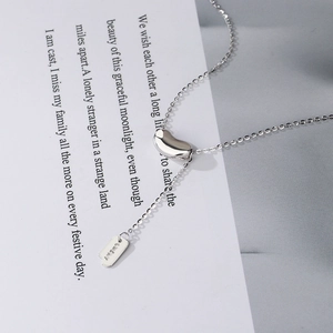 Macro shot of a 925 silver lucky bean necklace with an engraved LUCKY metal tag