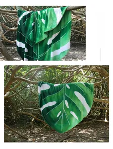 Detail of leaf-shaped green flannel blanket with white veins hanging in a forest
