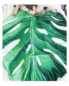 Detailed realistic leaf-shaped flannel blanket in deep green on a cozy white bed