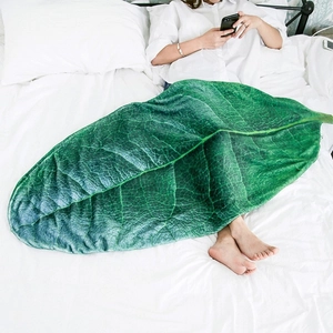 Detail view of leaf-shaped green flannel blanket with realistic vein textures on bed