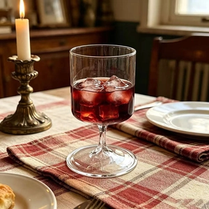 Macro shot of glass champagne flute with red wine and ice on a checkered tablecloth