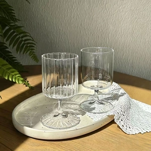 Detail of ribbed and smooth borosilicate glass stemware on a ceramic tray with lace