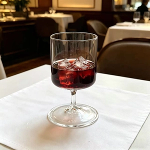 Detail of high borosilicate glass stemware with red juice and ice in a refined setting