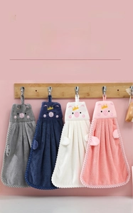 Close-up of soft coral velvet hand towels with cute cartoon pig designs and hanging loops