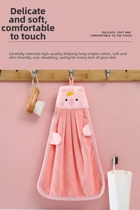 Macro detail of pink pig cartoon hand towel featuring soft coral fleece texture and embroidery