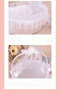 Close-up of wedding flower girl basket with white lace edges and satin ribbon bows