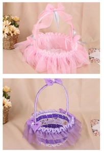 Detail view of woven flower girl baskets with lace skirts and pearl ribbon bows in pink and purple
