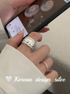 Detail of S925 sterling silver chunky twisted ring and minimalist band on finger