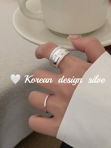 Detail of S925 sterling silver twist wheat ring and thin band on female hand