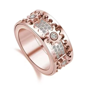 Close-up of rose gold gear ring with sparkling zircon stones in mechanical style