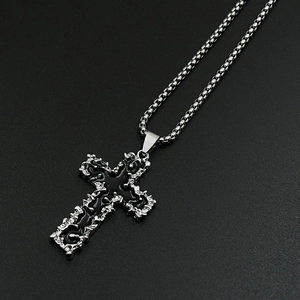 Detail of gothic silver cross pendant with black enamel inlay and box chain texture