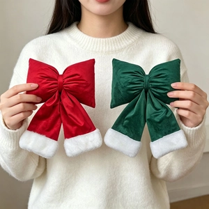 Detail of red and green velvet Christmas bows with plush white faux fur trim held by model