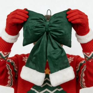 Close-up of dark green velvet Christmas bow with white faux fur trim and hanging string