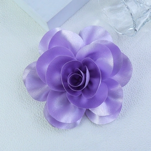 Detail of a 14cm lavender satin flower brooch with elegant layered petals and silk texture