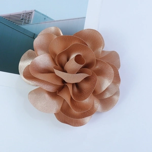 Macro detail of a 14cm bronze satin rose brooch featuring layered premium fabric petals