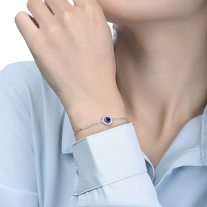 Detail of S925 sterling silver necklace with round sapphire pendant and white zircon halo
