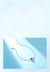 Macro shot of S925 sterling silver chain with halo-set blue sapphire pendant and clasp