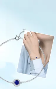 Detail showing a silver necklace with a sapphire pendant worn on a female neck