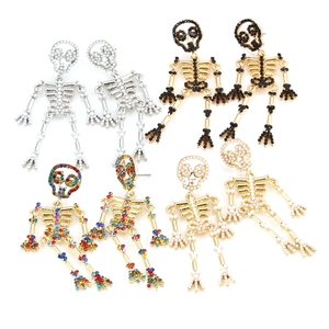 Detailed view of skull earrings with rhinestones and faux pearls in various finishes