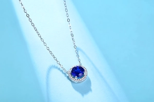 Close-up of S925 silver necklace with circular blue sapphire pendant and diamond halo