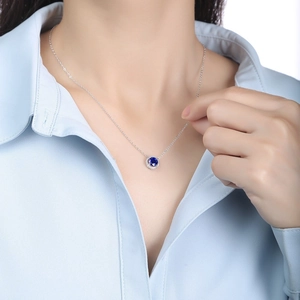 Elegant S925 sterling silver halo necklace with a deep blue sapphire pendant on a model