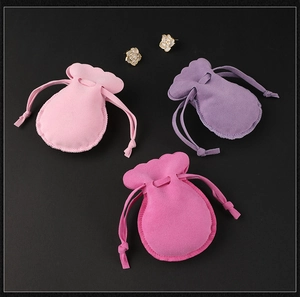 Close-up of velvet drawstring jewelry pouches in pink and purple colors for rings