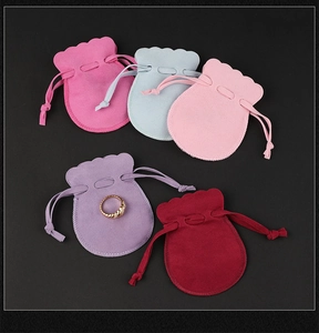 Macro detail of microfiber jewelry pouches in various colors with a gold ring for storage