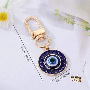Porte-clés œil bleu de 6,3 cm avec cristaux brillants sur fond de fleurs blanches fraîches