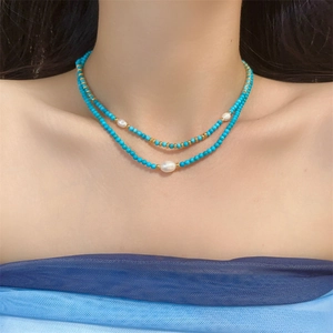 Double layer necklace with turquoise beads and freshwater pearls worn by a model