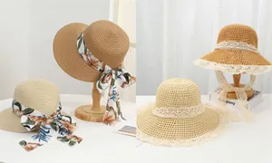 Detail of summer straw hats with floral satin ribbons and white lace decorations