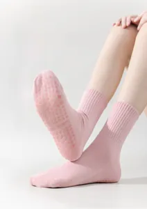 Detail view of pink yoga socks showing non-slip silicone grippers on the bottom soles