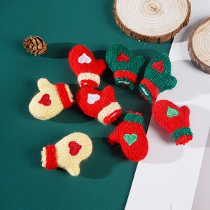 Detailed view of hand-knitted mini Christmas gloves with heart embroidery decorations