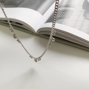 Macro shot of S925 silver beaded heart necklace on a white minimalist background