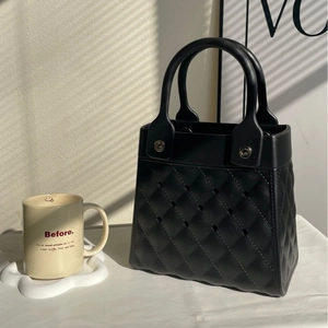 Classic black quilted EVA handbag with round handles and hollow out laser cut details