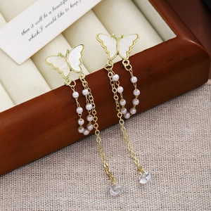 Detail of butterfly tassel earrings with gold finish, pink beads and crystal pendants