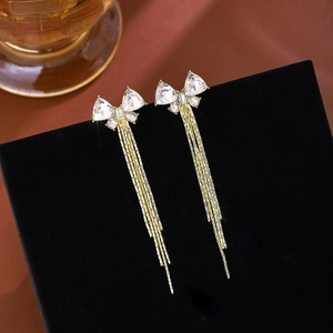 Detail view of gold butterfly tassel earrings with sparkling rhinestones on black stand