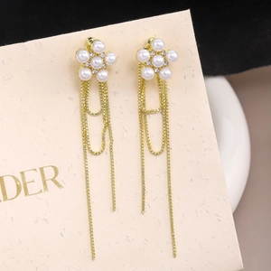 Close-up of elegant long tassel earrings with pearl flower studs and gold-plated fine chains