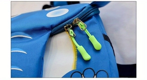 Detail of blue kids backpack with metal dual zippers and neon green pull cords