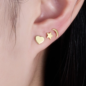 Minimalist gold star moon and heart stud earrings set for women shown on model ear