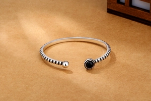 Detail of vintage silver cuff bracelet with black onyx stone and spiral texture