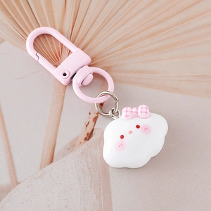 Dettaglio di un simpatico portachiavi a nuvola bianca con fiocco rosa e chiusura a moschettone