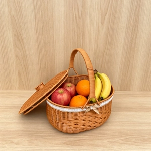 Detail of hand-woven wicker picnic basket with white lace trim and beige bow decoration
