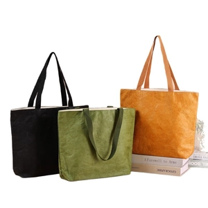 Washable kraft paper tote bags in black, green, and orange with durable handles