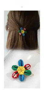 Macro detail showing colorful shell petal hair clip with woven yellow center and gold base