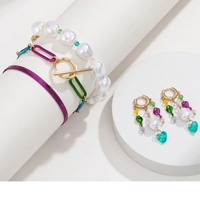 Dettaglio di set di gioielli con perle colorate, orecchini a cuore e bracciali