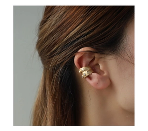 Close-up of matte gold double-layered ear cuff with pearls and rhinestones on a model