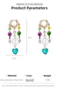 Dettaglio di orecchini a cuore in vetro colorato con perla barocca e ganci in lega oro
