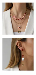 Close-up of elegant gold tiered heart necklace and long tassel earrings jewelry set