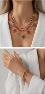 Detail of multi-layer gold necklace with red leather chain and XO letter pendants